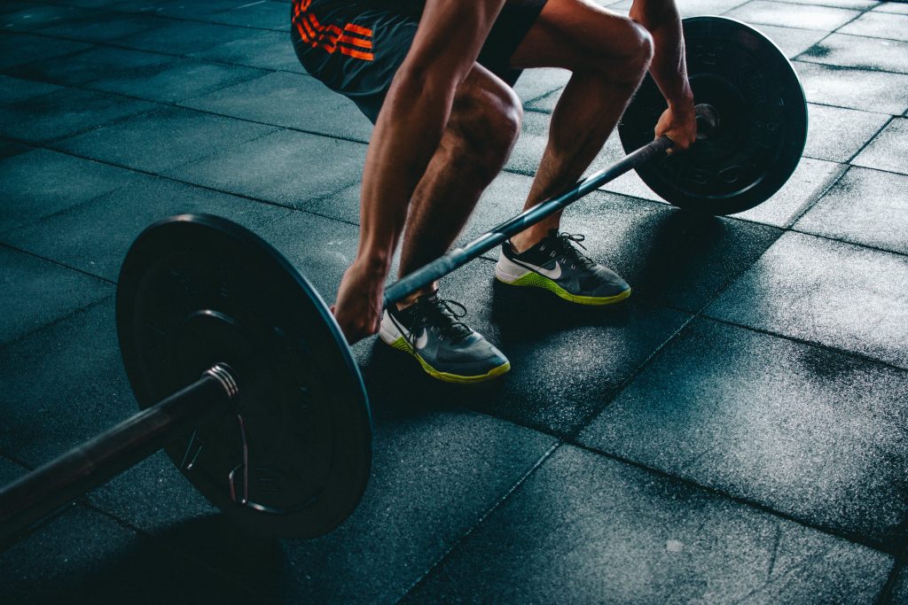 Person Lifting Weights At Gym